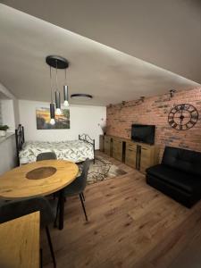 a living room with a wooden table and a brick wall at Apartament M1 w centrum Wiela in Wiele
