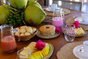 a table topped with plates of food and fruit at Alma Maraú - Praia do Cassange in Marau