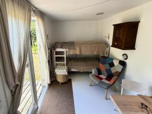 a small room with a bed and a chair and a window at Nøddehaven in Eg