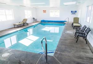 a large swimming pool with chairs in a room at Mountain View Lodge in Parowan