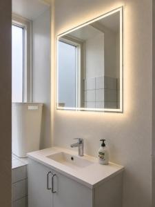 a bathroom with a sink and a mirror at NØ -Central Apartment Odense C in Odense