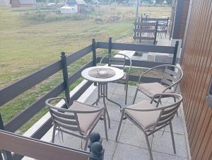 a patio with two chairs and a table on a balcony at Četiri sestre in Žabljak +1 photo