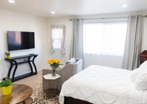 a bedroom with a white bed and a tv at Yellow Gate Executive Retreat in San Jose