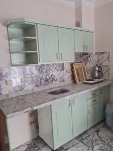 a kitchen with white cabinets and a sink at ÖZ-AY APART OTEL in Marmaris