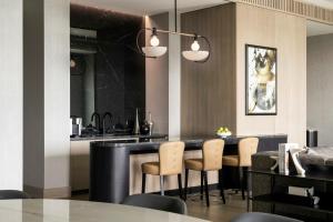 a kitchen with a bar with chairs and a table at Loews Arlington Hotel in Arlington