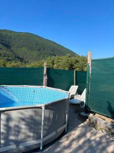 a deck with a table and chairs next to a body of water at Pliva Escape in Jezero