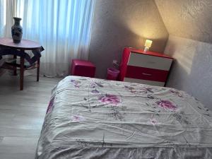 a bedroom with a bed and a dresser and a table at Casa Dany in Zărneşti