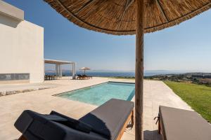 a villa with a swimming pool and an umbrella at Thalori villa 2 in Psalidi