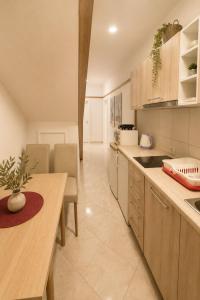 a kitchen with a counter and a table and chairs at Apartments Hollaj in Ulcinj