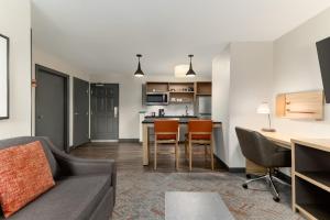 a living room with a couch and a kitchen at Candlewood Suites Oak Harbor by IHG in Oak Harbor