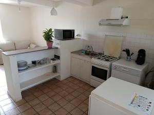 a small kitchen with a stove and a microwave at Maison Charton in Château-Chinon +4 photos