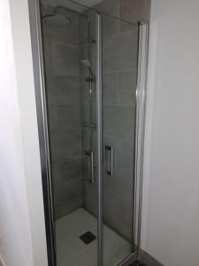 a shower with a glass door in a bathroom at Maison Charton in Château-Chinon
