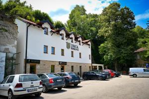 ein Gebäude mit auf einem Parkplatz abgestellten Autos in der Unterkunft Hotel Unca in Jajce