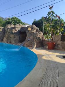 a swimming pool with a waterfall in a resort at ÖZ-AY APART OTEL in Marmaris