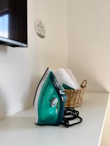 a green toaster sitting on a counter next to a basket at Pousada da Mariinha in São Lourenço