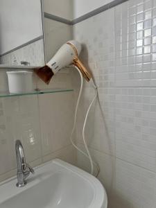a blow dryer in a bathroom next to a sink at Pousada da Mariinha in São Lourenço