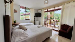 a bedroom with a bed and a chair and a window at Villa Jennifer in Tingo María