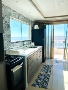 a kitchen with a sink and a stove and a window at Recanto Céu & Mar Casa de Praia em Manguinhos São Francisco de Itabapoana in São Francisco de Itabapoana