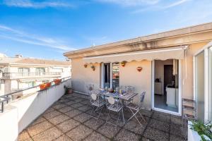 a patio with a table and chairs on a balcony at Victoria Bergamote Attic with Terrace and Sea View - Happy Rentals in Menton