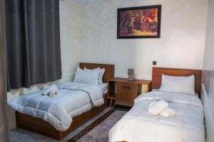 a room with two beds and a desk and a window at oasis house in Takchrirt +29 photos