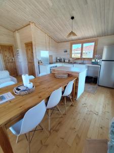 a kitchen and living room with a wooden table and chairs at Le chalet d'Agathe in Largentière