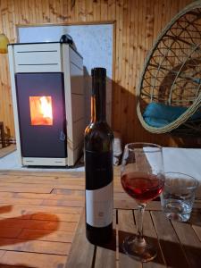 a bottle of wine sitting next to a glass of wine at Vikendica Zajecar in Zvezdan