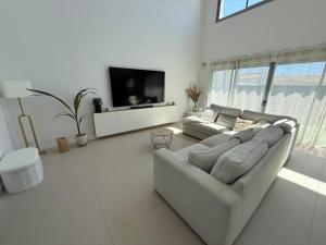 a living room with a couch and a flat screen tv at Maison des Oliviers in Puilboreau