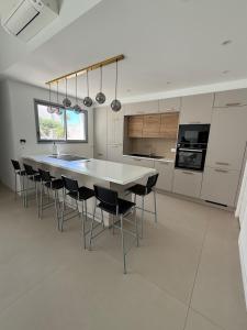 a white kitchen with a table and chairs at Maison des Oliviers in Puilboreau