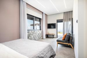a bedroom with a king sized bed and a chair at Thalori villa 1 in Psalidi