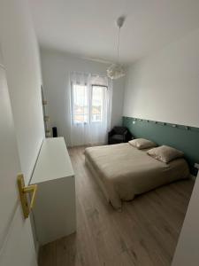 a bedroom with a bed and a desk and a window at Maison des Oliviers in Puilboreau +29 photos