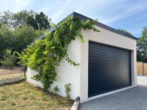 a garage door with a vine growing on it at Le Nid - Pause en Berry in Vignoux-sur-Barangeon