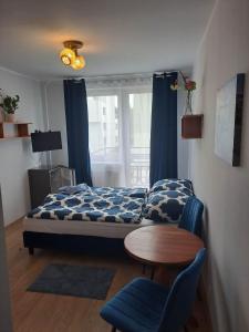 a bedroom with a bed and a table and a chair at Pokoje gościnne u Aleksandry in Hel