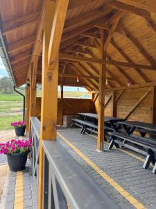 a wooden pavilion with potted plants and flowers on it at Dolina snów in Kruklanki