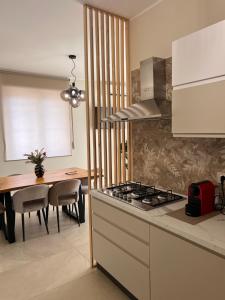a kitchen with a stove top oven next to a table at Zen Apartment in Santa Maria del Cedro
