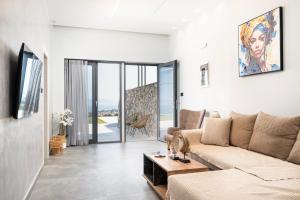 a living room with a couch and a table at Thalori villa 1 in Psalidi