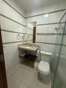a bathroom with a toilet and a sink at Residencial DOM in Lorena