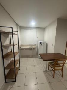 a room with a shelf and a table and a refrigerator at Residencial DOM in Lorena +3 photos