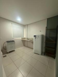 a kitchen with a refrigerator and a tiled floor at Residencial DOM in Lorena