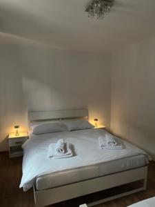 a bedroom with a white bed with towels on it at Wellness apartment Karlštejn in Karlštejn +23 photos