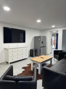 a living room with a table and a tv at Wellness apartment Karlštejn in Karlštejn