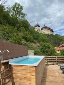 a pool with a chair and a castle in the background at Wellness apartment Karlštejn in Karlštejn