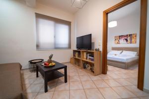 a living room with a room with a bed and a table at Rosso 3 City Centre Apartment in Heraklio