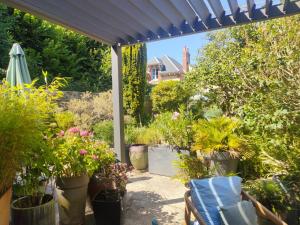 a patio with potted plants and an umbrella at Maison La Suite 27 in Guingamp