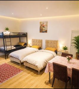 two beds in a room with a table and a bunk bed at "Aux Portes de CDG" in Thieux