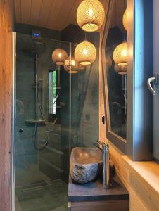 a bathroom with a shower with a sink and a sink at Domy Kopułowe 5th Wymiar in Skrybicze