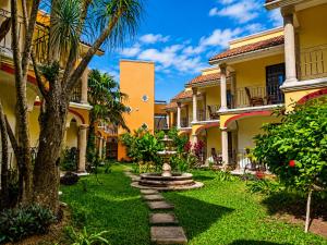 a courtyard of a house with a fountain and palm trees at Ecotel Quinta Regia in Valladolid