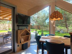 a dining room with a table and a large window at Domy Kopułowe 5th Wymiar in Skrybicze +22 photos