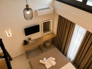 a small room with a bed and a desk with two towels at GLP Sivota in Syvota