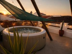 a hammock on top of a balcony with a plant at Pátio 38 do frade in Aldeia do Mato
