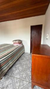 a bedroom with a bed and a wooden dresser at downtown Teófilo Otoni in Teófilo Otoni +2 photos